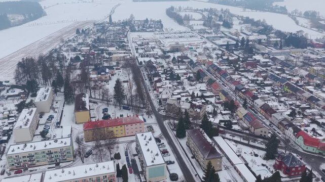 Drone view of a road in the snow-covered town of Svitavy in the Czech Republic. Residential buildings with colorful roofs.