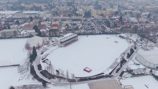 Snow-covered sports stadium seen from a drone. Aerial shots of the city in winter. Svitavy, Czech