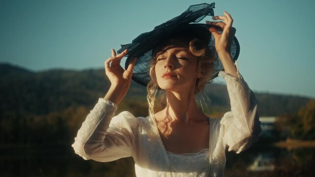 Traveler Wears Sunhat. Casual Explorer Adjusting Her Hat Amid Glowing Sunshine On Gentle Grassy Slope