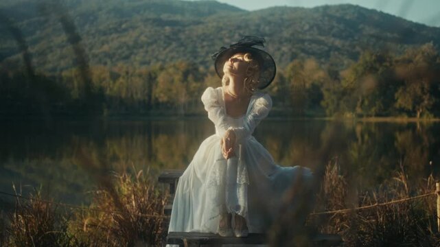Graceful Woman Dressed In White With Suitcase Taking Slow Walk Near Tranquil Mountain Shoreline