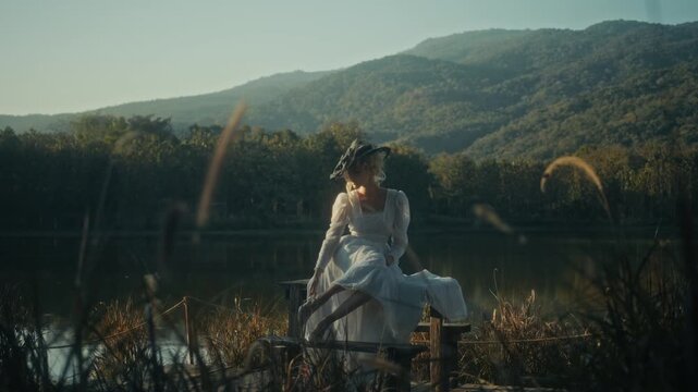 Serene Image Of Woman Wearing White Gown Sitting Peacefully By Calm Lakeside Surrounded By Nature
