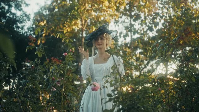 Lady Tending Vibrant Roses In Garden. Graceful Woman Caring For Blooming Roses Under Gentle Sunlight
