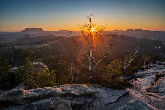 Sonnenuntergang in der Felsenlandschaft - Nationalpark S&auml;chsischen Schweiz vom Gamrig. Panorama-Blick auf Lilienstein, Festung K&ouml;nigstein, B&auml;rensteine das Elbtal, Kurort Rathen im warmen Abendlicht