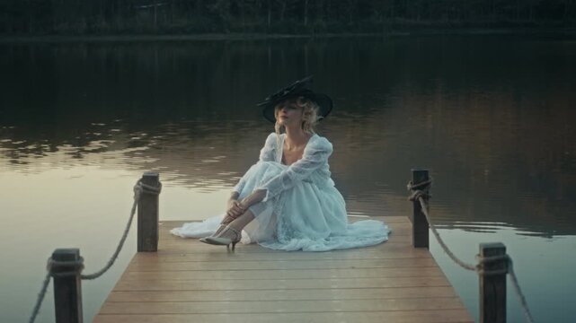 Woman In Dress Near Tranquil Water. Gentle Dusk Glow Illuminates Tranquil Lakeside With Peaceful Lady