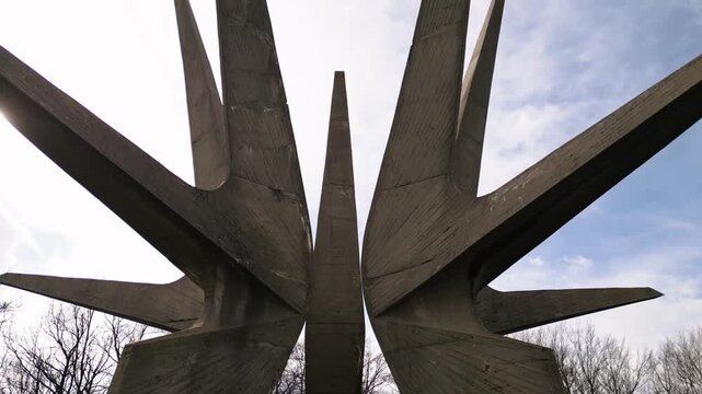 Aerial drone footage of the Kosmaj Monument in Serbia, capturing its brutalist concrete structure against the sky. Memorial site from above.
