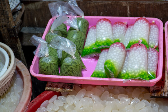 Traditional Indonesian dessert ingredients green rice flour jelly cendol and tapioca pearls sagu mutiara in plastic bags at local market