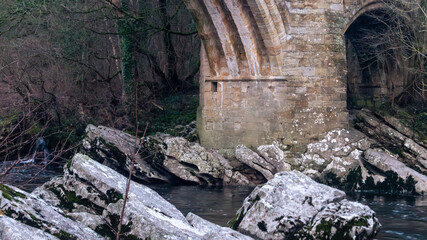 Large stone boulders near the river under the old bridge. River with boulders under Devil's Bridge © mikus