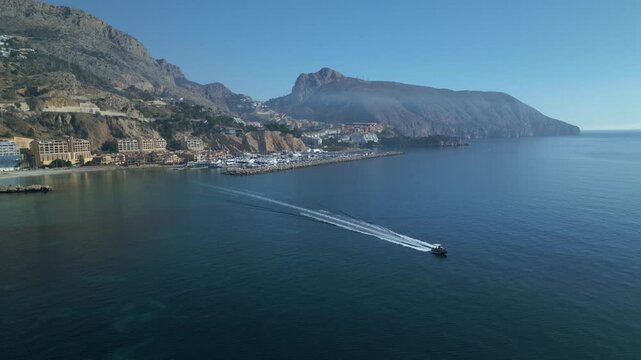 Speedboat cruising along a mountainous coastline
