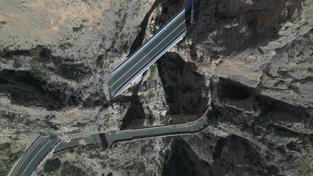 Aerial view of vehicles driving across a canyon bridge