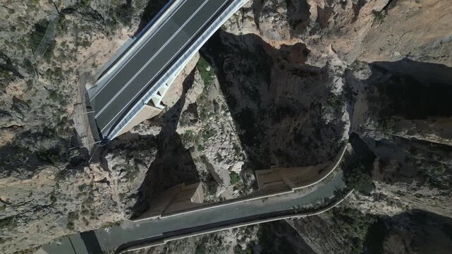 Aerial view of vehicles crossing a modern bridge over a canyon
