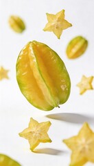 Fototapeta premium Fresh star fruit slices and whole fruit floating against a clean white background