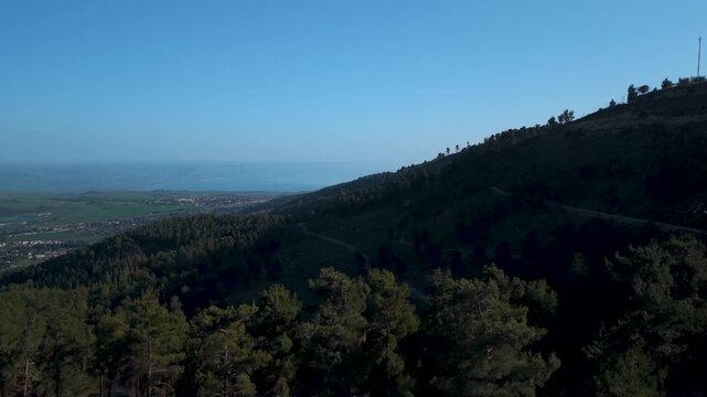 Biriya Forest aerial view with the Sea of Galilee and Golan Heights mountains visible in the hazy distance of Israel.