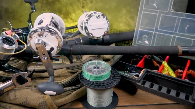 Fishing tackle is laid out on a wooden background, slowly moving along a horizontal plane. Fishing tackle for fun.