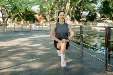 Fototapeta premium Female athlete doing lunges on stone steps, focused on warm up training