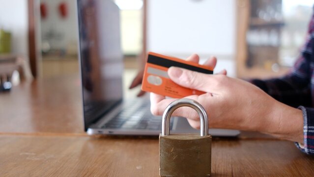 Person making a secure online purchase using a credit card and laptop, emphasizing cybersecurity, personal data privacy, and safe internet banking practices