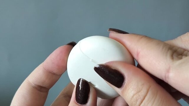 A woman's hand opens the container and pulls the dental floss out of the container. Teeth cleaning, interdental cleaning