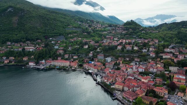 Aerial Drone View of Menaggio, Lake Como, Italy &ndash; Alpine Town with Terracotta Roofs, Boats on Blue Water and Cloudy Alps Mountains Landscape, 4K