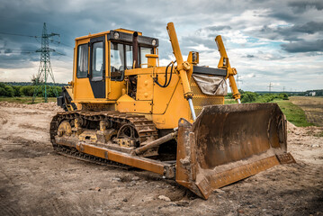Yellow bulldozer on construction site in cloudy day