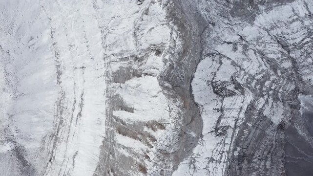 Sunrise light over Throne of Zeus peak, drone top down abstract of escarpment ridgeline in snow