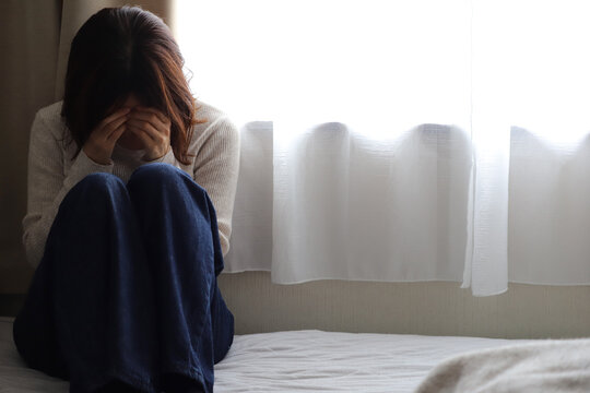 窓辺で落ち込む女性