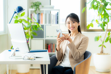 オフィスでスマホを使うビジネスウーマン