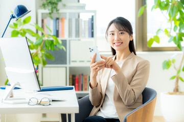 オフィスでスマホを使うビジネスウーマン