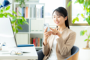 オフィスでスマホを使うビジネスウーマン