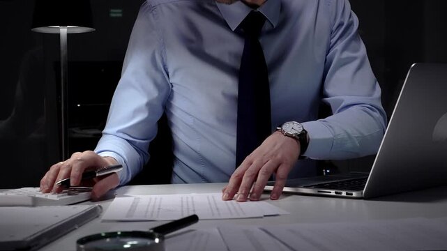Businessman working late at night, typing on laptop, meeting deadlines and managing corporate finance administration. Audit and taxes in business