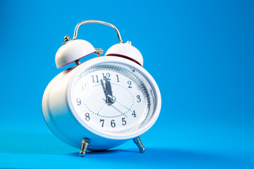 Alarm clock on blue background. Time concept. Copy space.