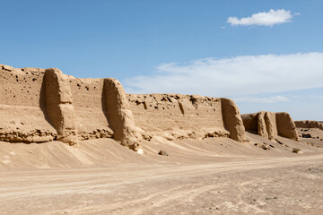 Ancient Desert Ruins with Crumbling Earthen Walls under Clear Blue Sky in Arid Wasteland Landscape for Travel or Historical Documentary Use