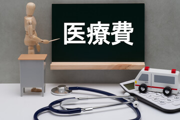 黒板に書かれた医療費と救急車と聴診器