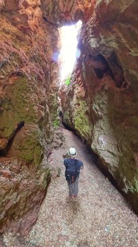 Hiker walking through a narrow rock canyon in Quebrada del Toro, Lagunas de Ruidera, Spain, experiencing adventure and nature in the unique geological formation. Ossa de Montiel, Albacete