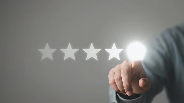 Close-up of a persons finger touching the fifth glowing white star in a row, the star pulses with bright light upon contact against a neutral grey background, static framing with soft studio lighting,