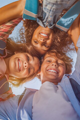 Low angle, diversity group of friends classmates with smile in playground for solidarity, teamwork playing together. Huddle portrait and happy children in school for education, support or development. © InsideCreativeHouse