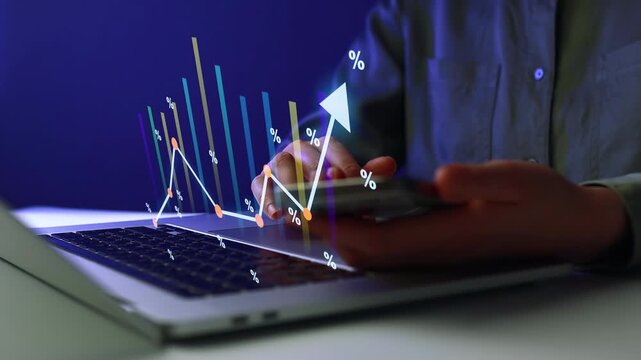 Hands working on laptop with data charts and graphs showing growth in financial metrics and market trends in a dark environment.