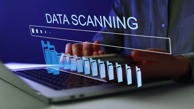 User engaged in data scanning on a laptop with a loading bar displayed on the screen in an office setting at night.