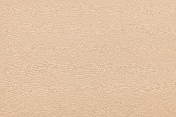 A full-frame top-down view of a light beige faux leather material showing a fine grained texture...