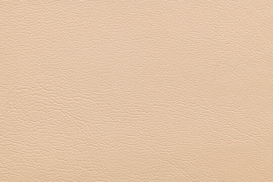 A full-frame top-down view of a light beige faux leather material showing a fine grained texture with subtle wrinkles and a matte finish suitable for upholstery or fashion backgrounds