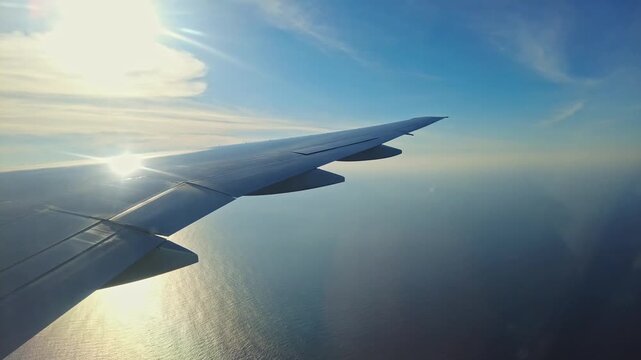 Beautiful view of airplane wing flying over Caribbean Sea at sunset. Aruba.