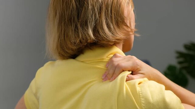 Blonde Woman 40+ Suffering from Shoulder and Trapezius Muscle Pain at Home