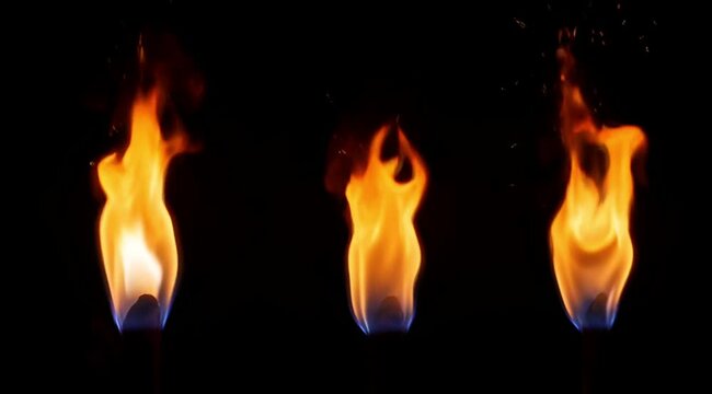 Four Bright Orange Fire Flames Burning in a Row on Black Background