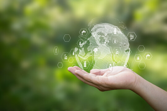 Digital globe on hand with eco icons. Concept of green business, World Environment Day, earth care, and eco-friendly industry for sustainability.