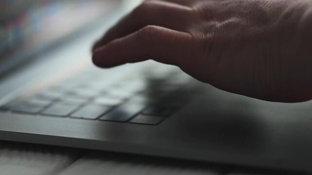 Freelancer working on laptop at wooden table in cafe, close-up of hands