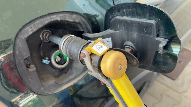 Close-up video of a car being refueled with LPG at a gas station. Fuel nozzle securely connected to the vehicle tank inlet during the refueling process. Concept of alternative fuel, energy supply