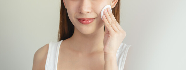 Close-up view woman using toner and cotton pad to remove makeup © Pormezz