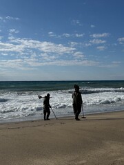 Metal detector search. Beach metal detecting. A metal detector in hand in nature, a seascape during...