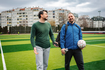 Two men walking on soccer field after playing © Jelena