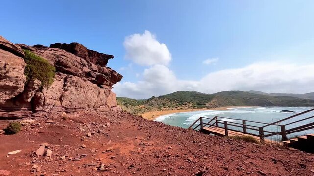 Rocky cliffside overlook of sandy beach and ocean in Menorca Spain
