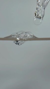 Beauty serum liquid dripped from the tip of the serum pipette, forming a liquid bubble