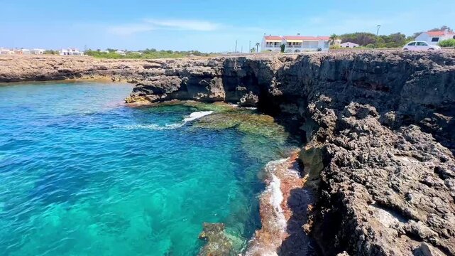 Crystal clear turquoise water along rocky limestone coast in Menorca